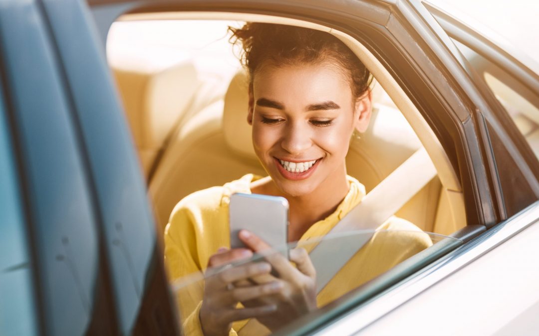 African-Americam Woman Texting On Phone In Car